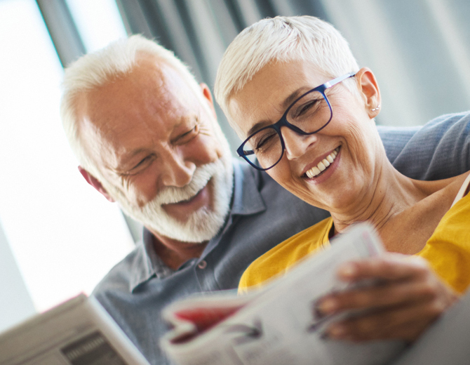 Two people sitting on a sofa smiling