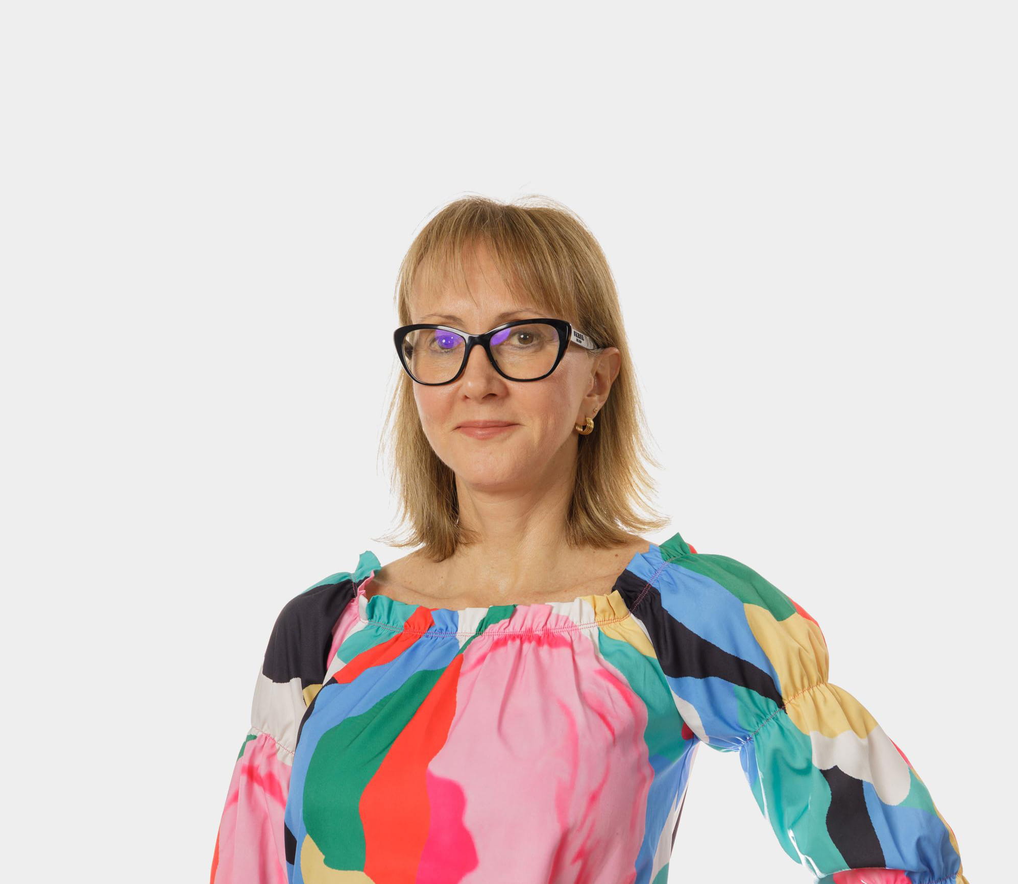 Women in brightly coloured top with hand on hip