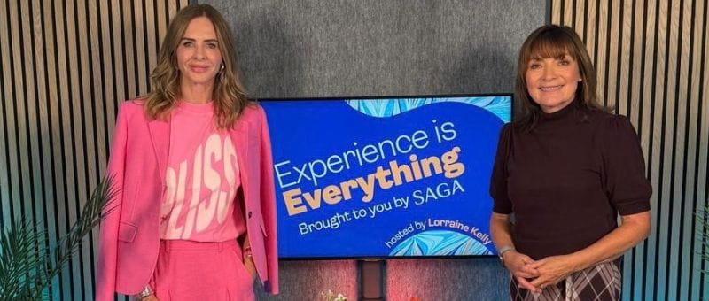 Trinny and Lorraine standing beside a screen displaying the message “Experience is Everything” and “Brought to you by SAGA,” with a smaller logo beneath.