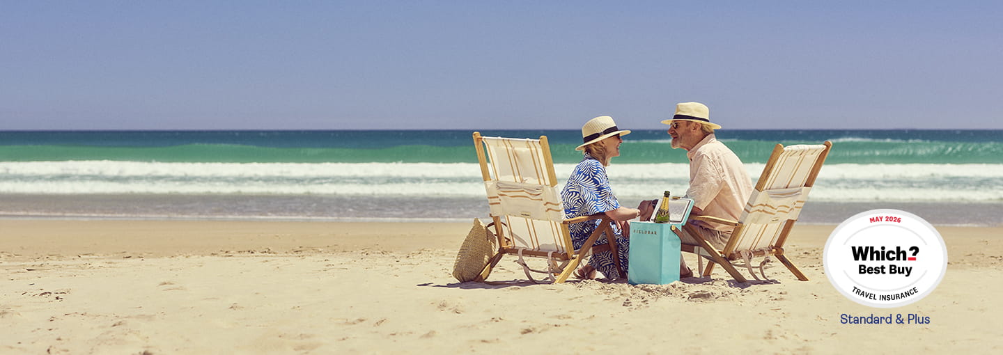 Two people sitting in deck chairs on a sandy beach, facing each other with the sea in the background and a Which? Best Buy logo