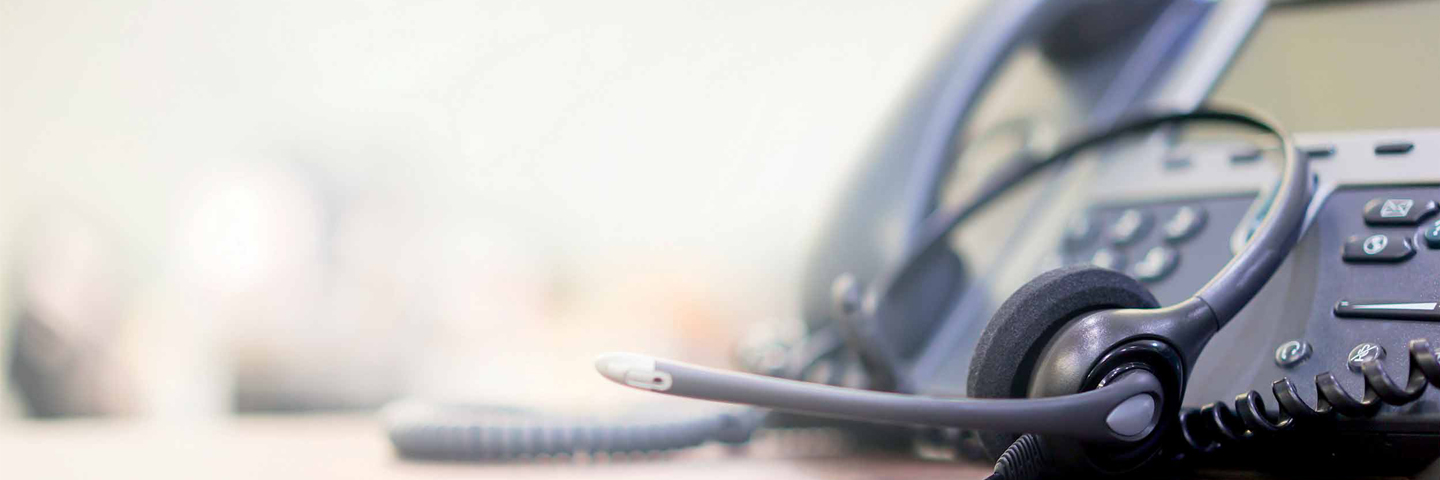 close up of a landline telephone and a microphone headset