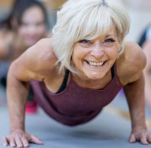 A happy mature woman in a yoga class