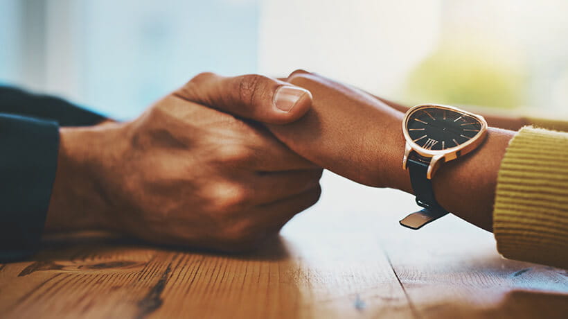 Close up of hands being held across a table