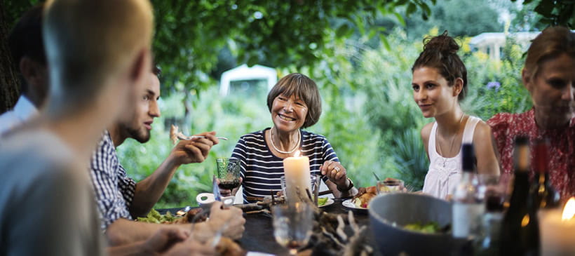 Different generations of the same family enjoying a meal in the garden of their home
