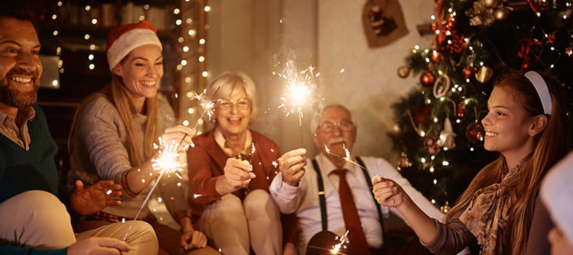 A multi-generational family celebrating with sparklers inside.