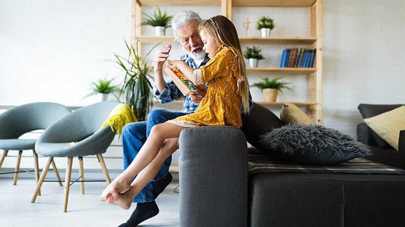 A man with his Granddaughter looking at an abacus