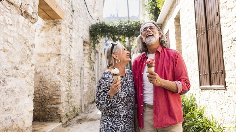 Mature tourists enjoying local ice cream while walking through an old town in Cyprus