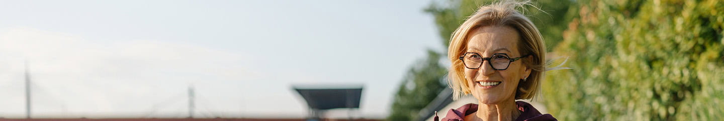 A mature woman running along a promenade on a sunny day.