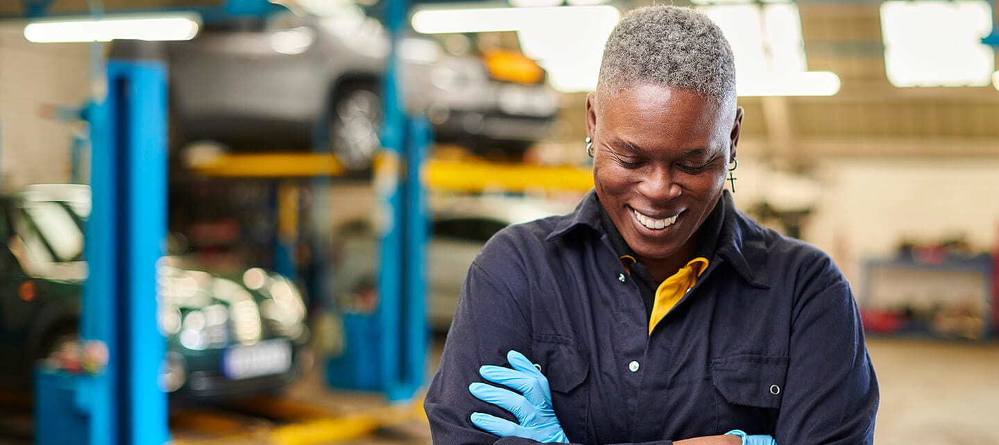 Laughing garage worker stood in a workshop