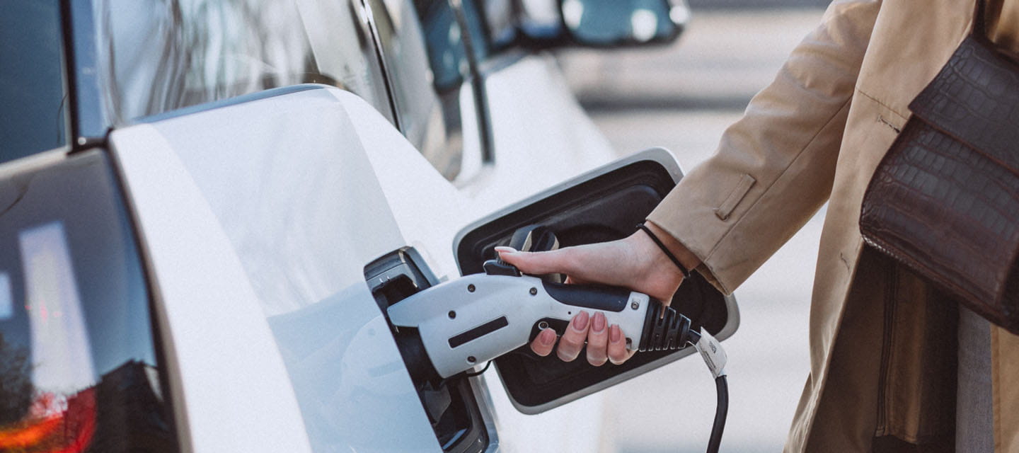 A woman charging her electric car