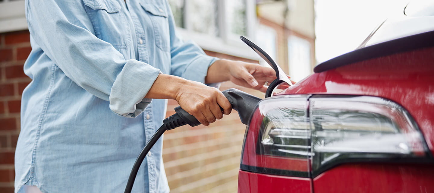 A woman charging her electric car