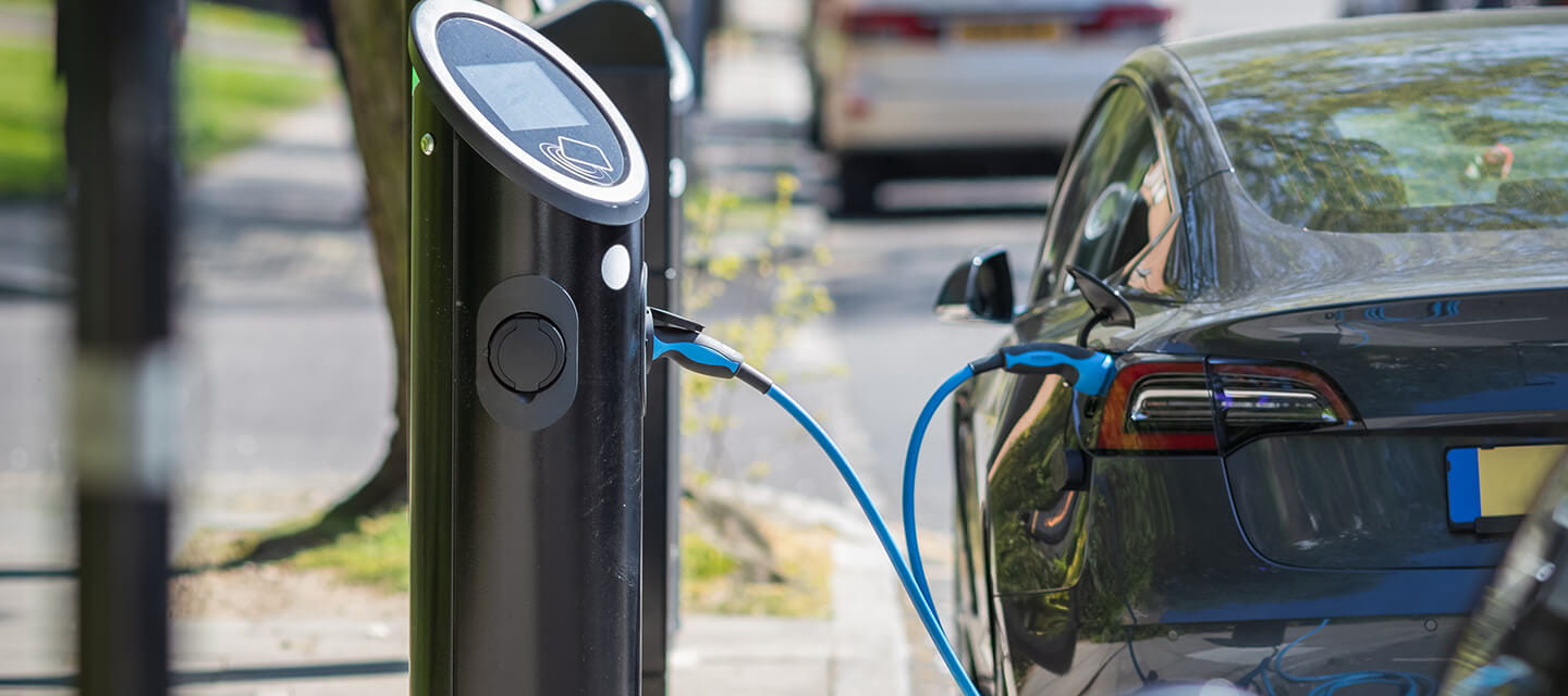 An electric car charging on a street