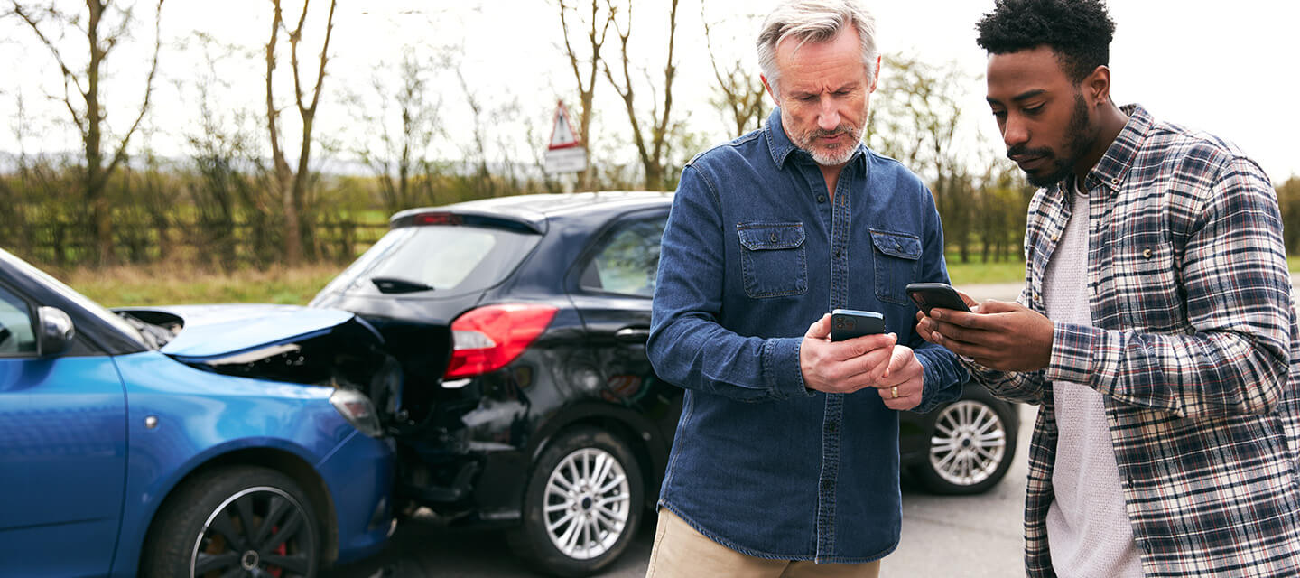 Two men exchanging information after a car accident