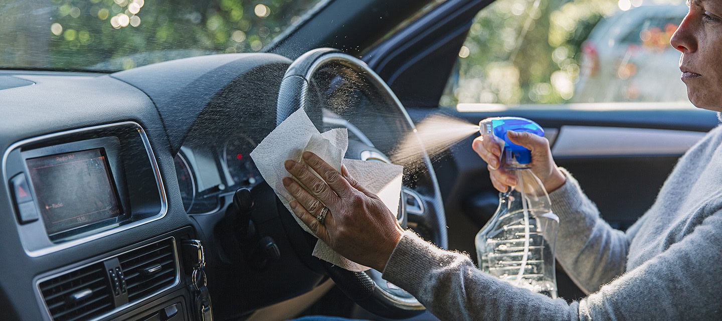 Woman wiping down car steering wheel