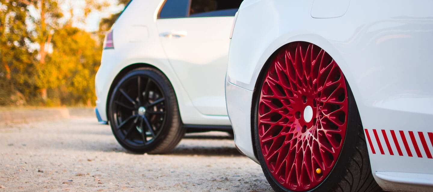 The rear end of 2 cars parked next to each other