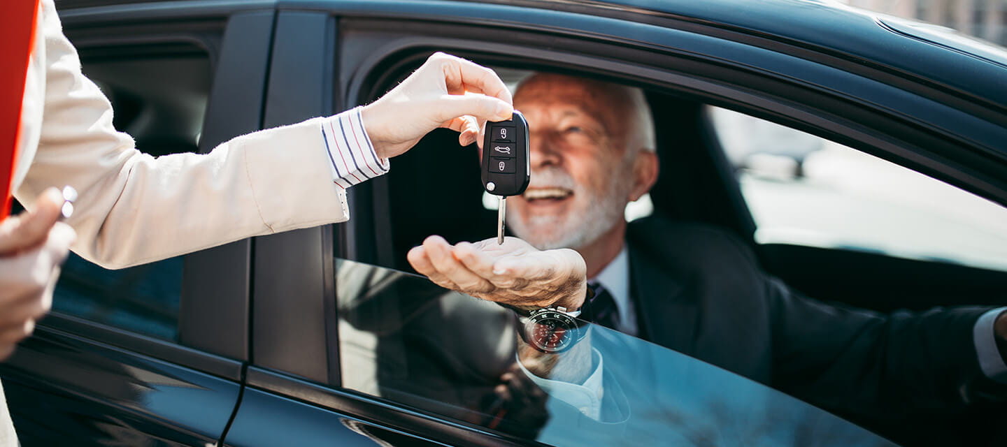 A man being handed the keys to a car he has purchased