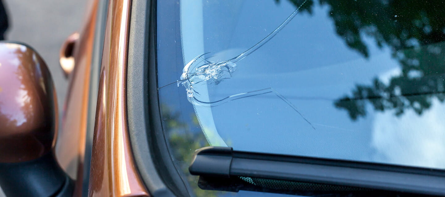 A large crack in the bottom corner of a car windscreen