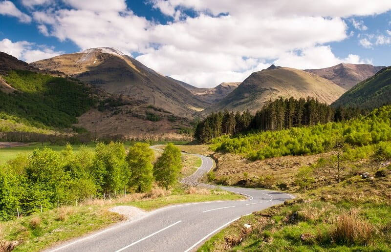 The valley of Glen Nevis beneath the mountain Ben Nevis on a partly cloudy but bright day