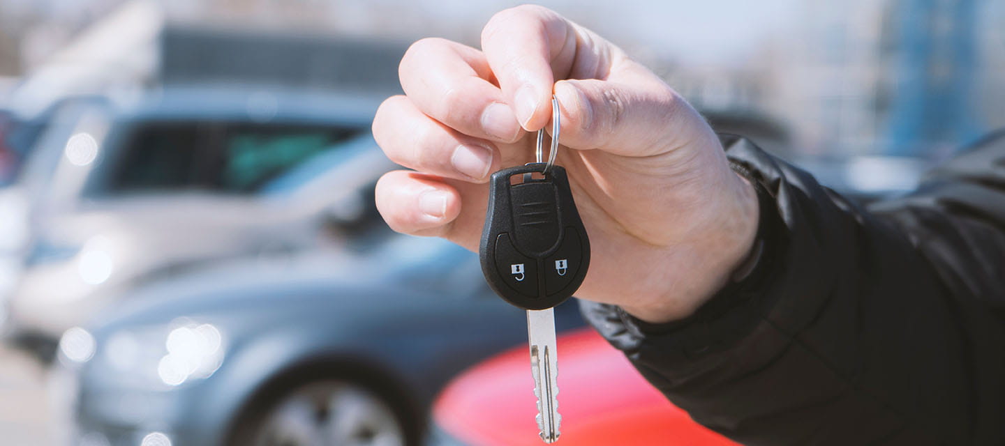 A hand holding a single car key