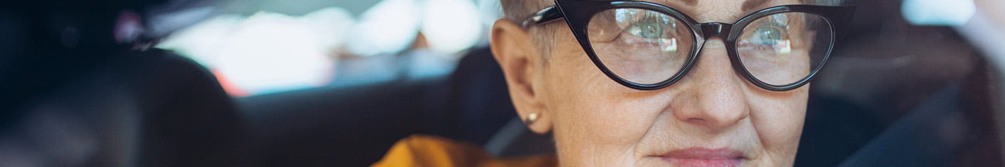 An elegant mature lady gazing longingly out of her car window