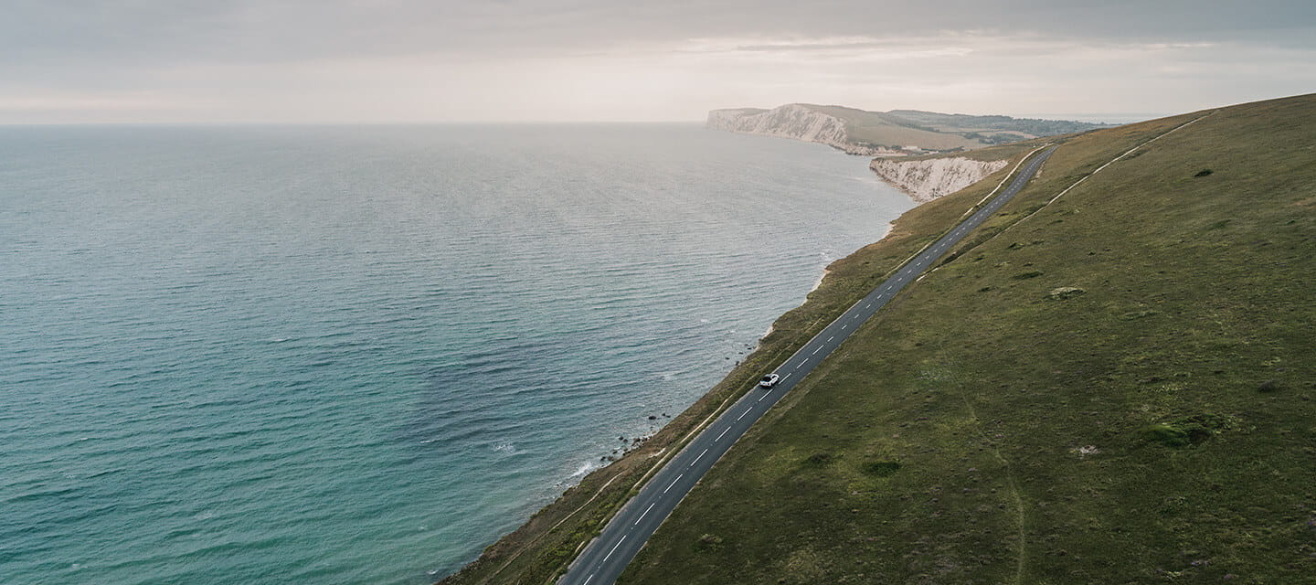 Car driving along a road on the Isle Of Wight coastline