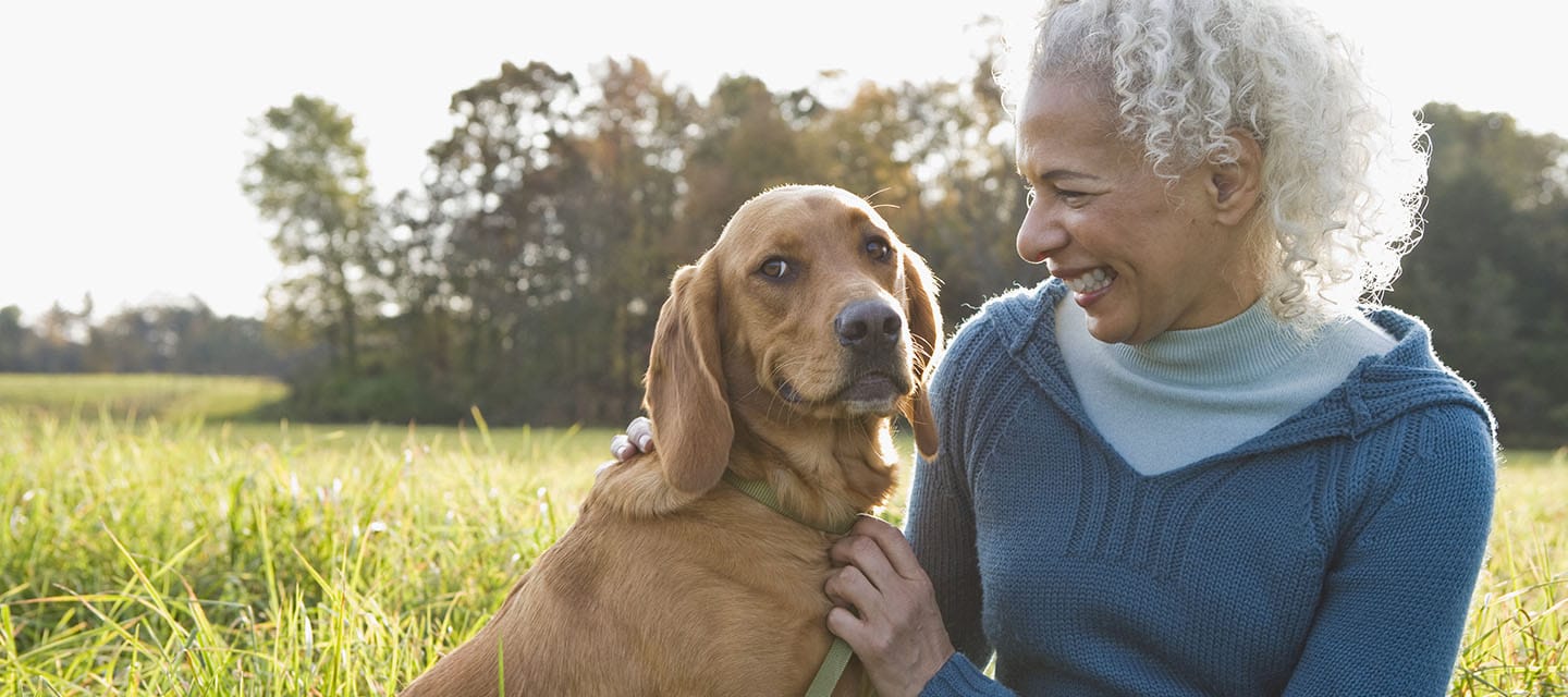 A mature woman staring lovingly at her pet dog