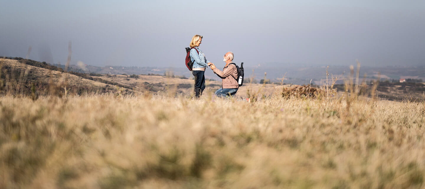 Senior man proposing to his partner in nature.