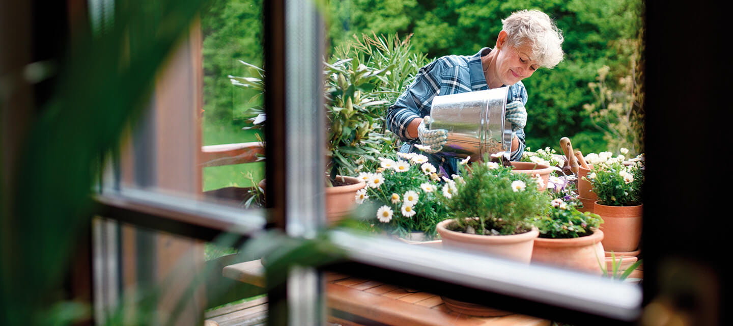 A woman potting plants on her garden table