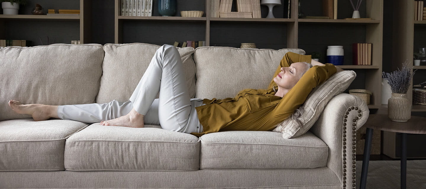 A mature woman relaxing on her sofa at home