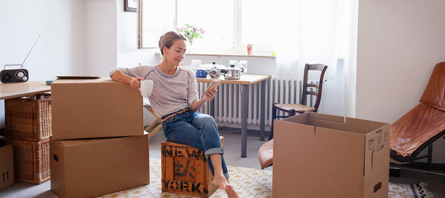 A mature woman taking a break from packing boxes in her living room