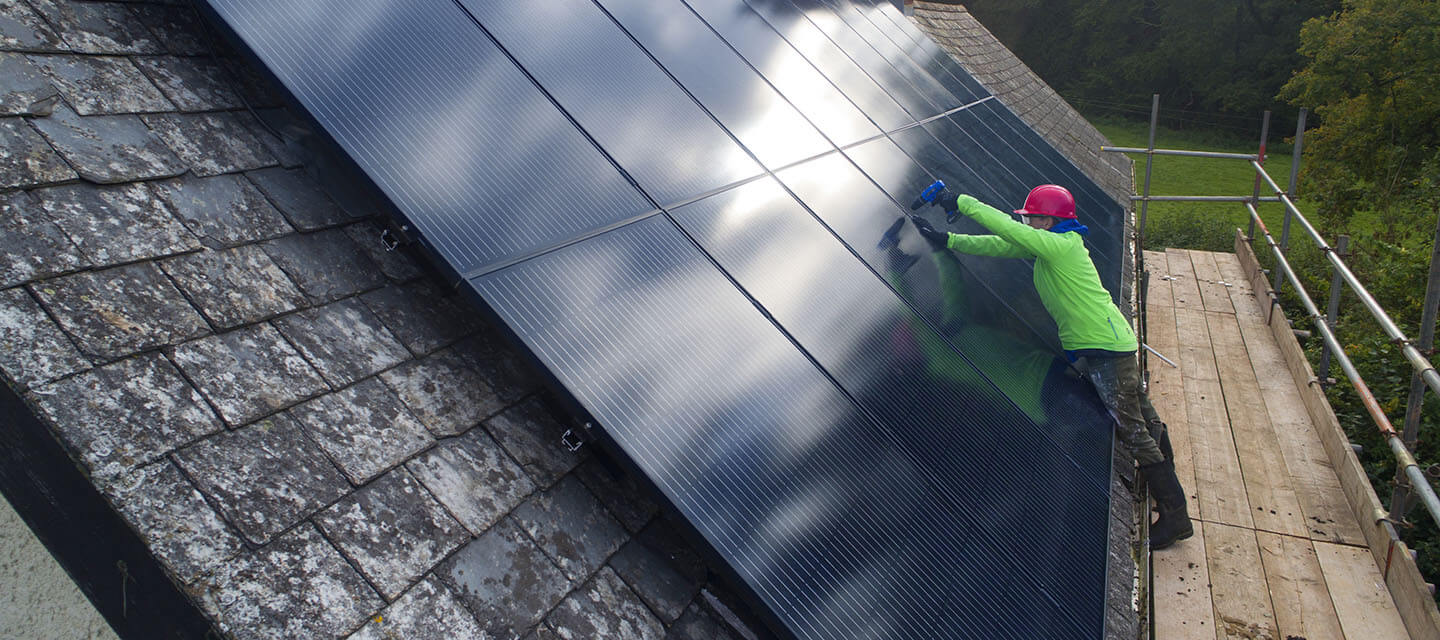Man attaching solar panels to roof