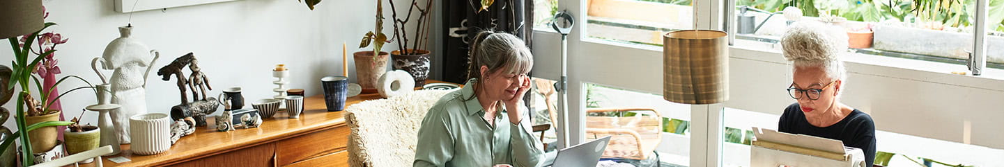 Two craft enthusiasts working at dining room table