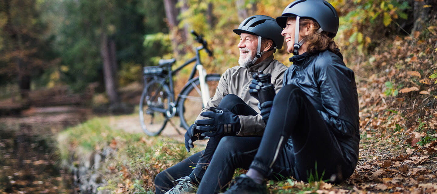 A couple of cyclists relaxing next to a river in autumn