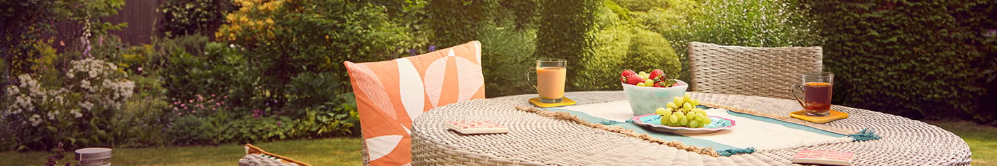 An outdoor garden table laid ready for breakfast on a sunny day