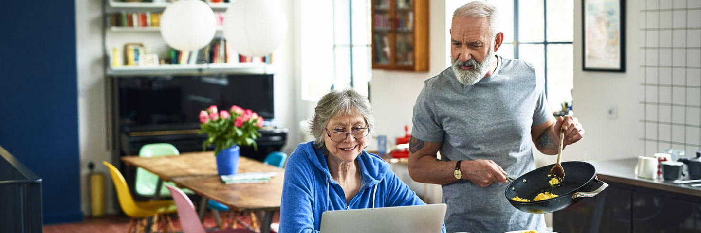 A couple at home looking at their laptop