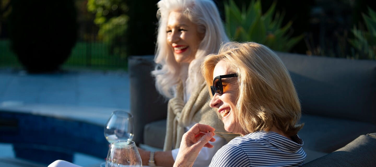 Two ladies enjoying the evening sunshine sat in their holiday home garden