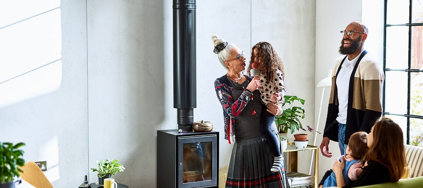 A grandmother entertaining her family while holding her granddaughter