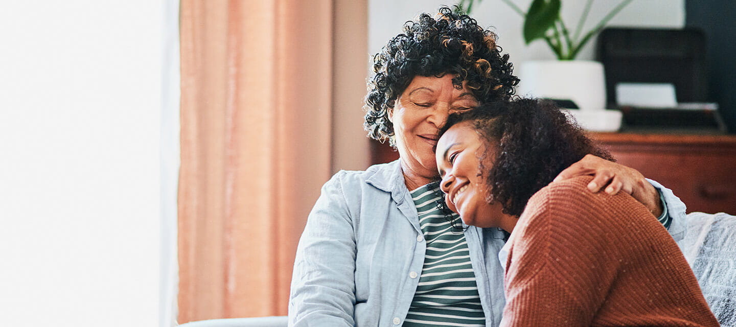 A senior woman relaxing with her granddaughter on the sofa at home 