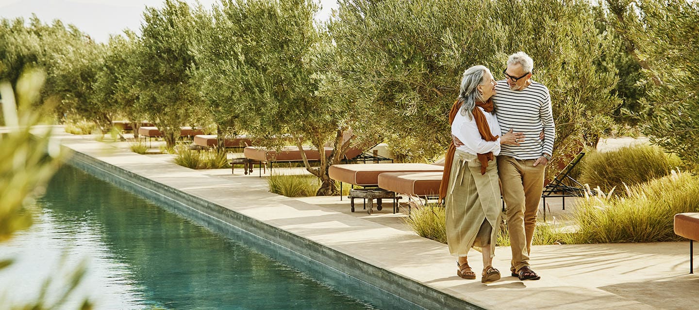 couple walking along a swimming pool