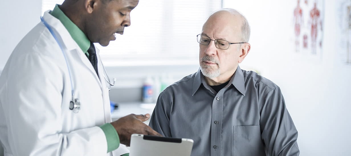 A senior man having a consultation with a doctor in a white coat.
