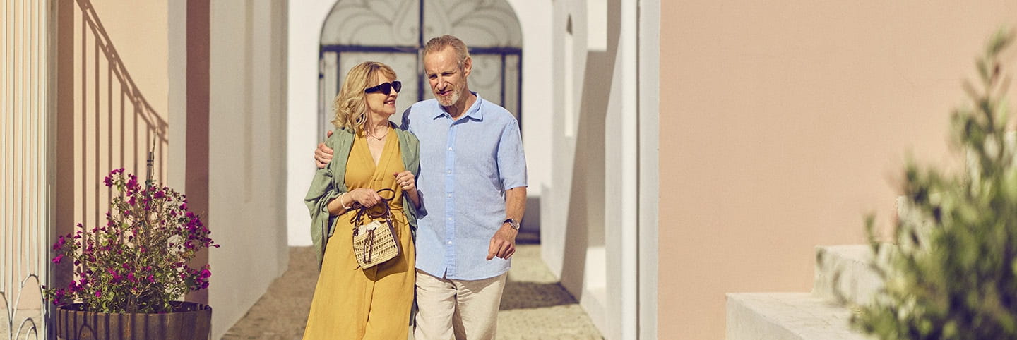 A senior couple walking through a Mediterranean hotel on holiday