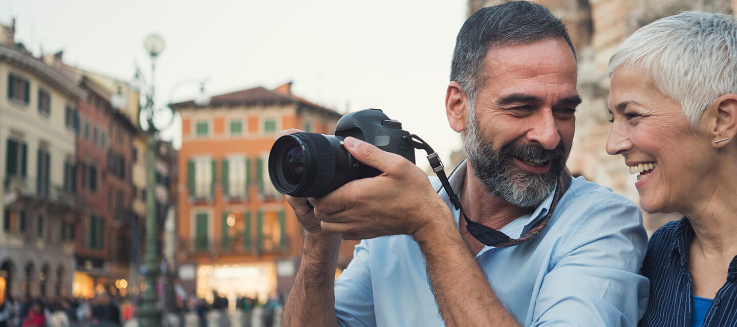 Mature couple taking photos as tourists in the city of Verona