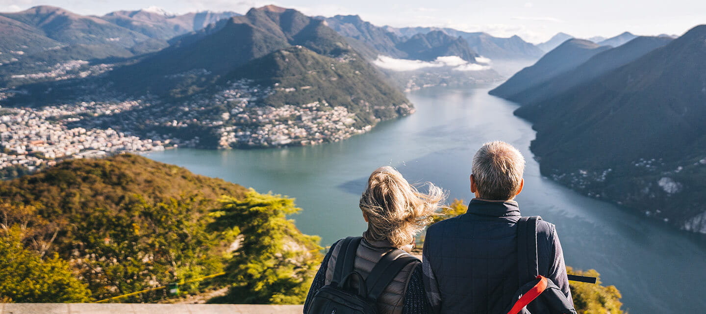 Mature couple hike above lake Lugano in the morning