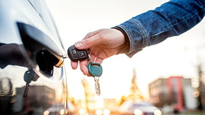 A close up image of a car being unlocked with a key