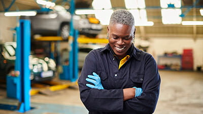 Laughing garage worker stood in a workshop
