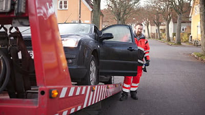 A man preparing a car to get towed
