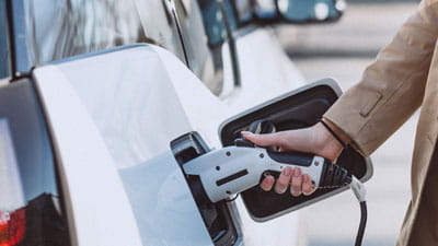 A woman charging her electric car