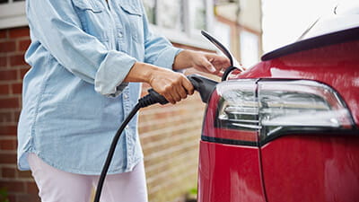 A woman charging her electric car