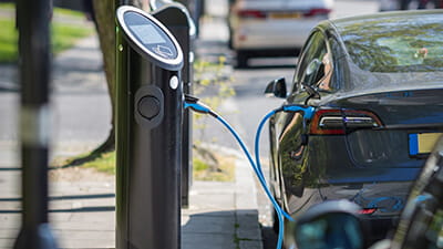 An electric car charging on a street