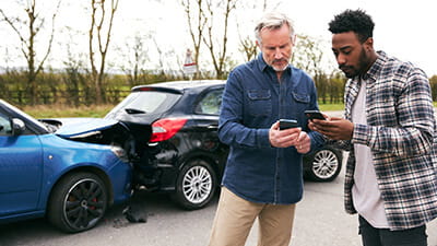 Two men exchanging information after a car accident